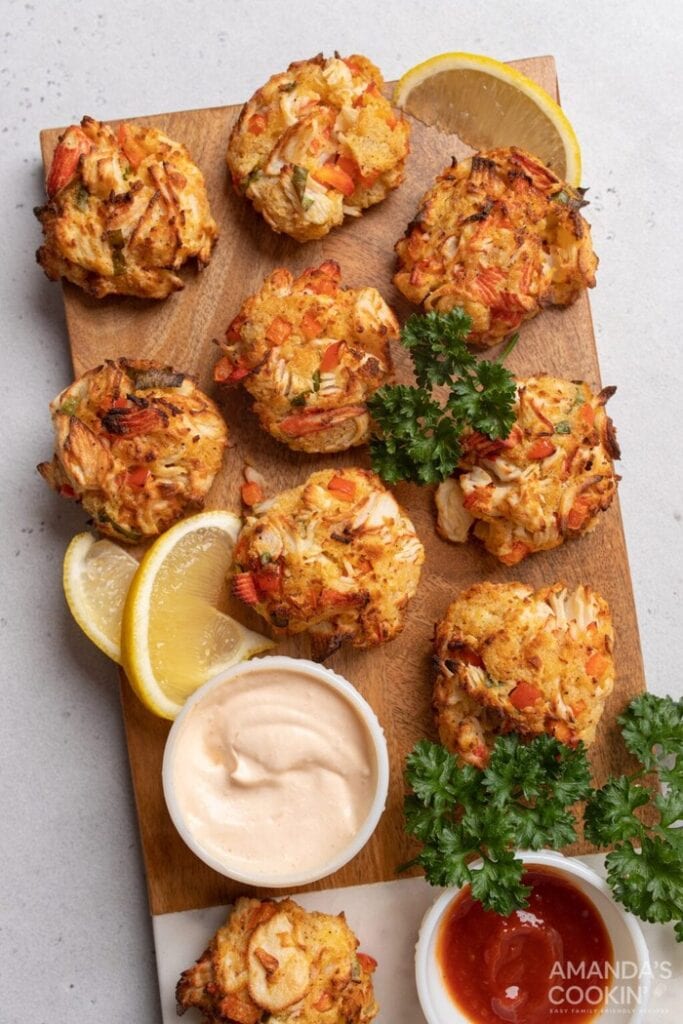 Golden air fryer crab cakes made with lump crab meat and diced peppers, served with lemon wedges, fresh parsley, and dipping sauces.