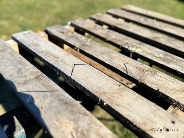 Pallet boards marked with angled cut lines for creating pointed pickets on a DIY Halloween fence.
