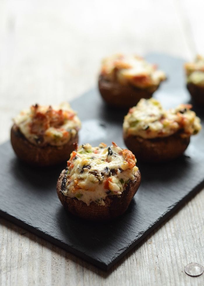 Baked baby bella mushrooms filled with a creamy cheese and pepperoni mixture, topped with golden brown Parmesan cheese.