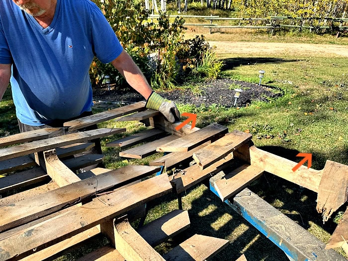 Removing the top half of a pallet to create a DIY Halloween fence section.