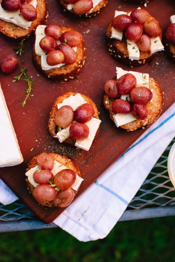 Roasted red grapes served on toasted crostini with creamy brie cheese and fresh thyme.