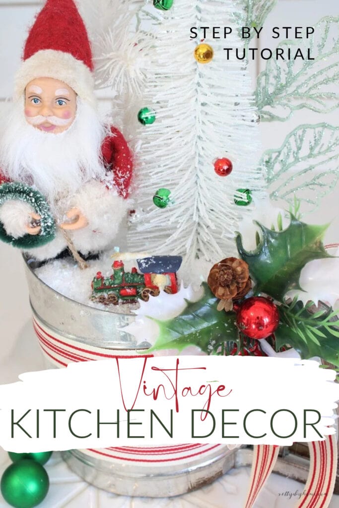 Pinterest pin featuring DIY vintage Christmas kitchen decor made with an old flour sifter, Santa Claus, white bottle brush tree, and miniature Christmas ornaments.