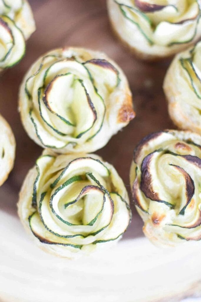 Golden zucchini puff pastry roses made with thinly sliced zucchini and creamy goat cheese filling, baked into individual flower-shaped appetizers.